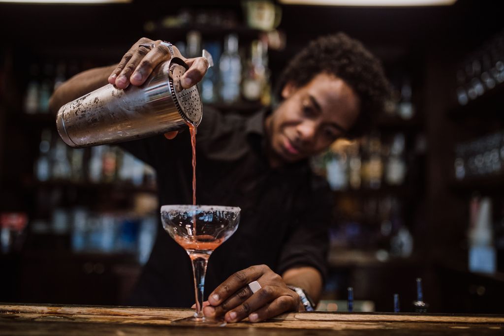 mixologist pouring a cocktail